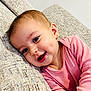 Alin is registered to the contest to win money with this photo: baby, child, smiling, couch, pink_clothing, earring, face, portrait, cute, happy, indoors, young_child, head, skin, person, sitting, cozy, expression, closeup, infant