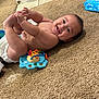 Izan joined the competition — help win amazing prizes! baby, smiling, carpet, toy, elephant_toy, diaper, clothing, infant, happy, child, floor, playtime, colorful, hand, feet, person, lying_down, indoors, cute, toddler