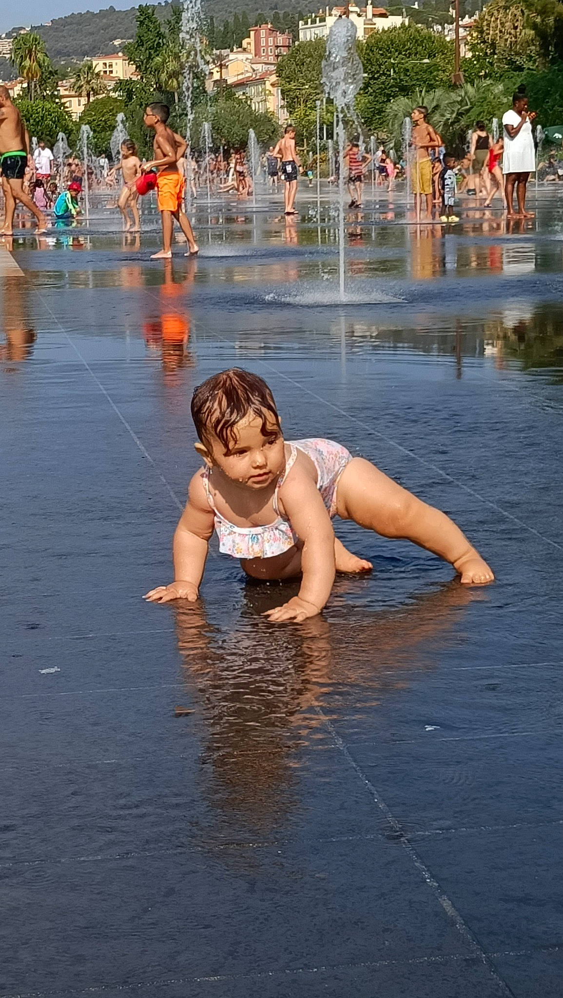 Mia participe au concours pour gagner de l'argent avec cette photo : barechested, barefoot, bathing, body_of_water, city, event, flooring, fountain, fun, happy, leisure, person, recreation, reflection, shorts, summer, toddler, tree, vacation, water