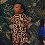 baby, infant, pacifier, onesie, leopard_print, blanket, floral_pattern, bottle, blue, lying_down, bed, sleepwear, cute, newborn, child, person, cozy, indoor, soft, resting
