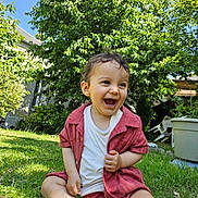 Daniel participe au concours pour gagner de l'argent avec cette photo : toddler, child, grass, outdoor, smiling, laughing, curly_hair, red_shirt, white_shirt, garden, greenery, sunlight, blue_sky, barefoot, nature, happy, summer, casual_clothing, sitting, playful