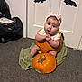 Megan joined the competition — help win amazing prizes! baby, pumpkin, headband, carpet, door, blanket, indoors, child, halloween, decoration, orange, sitting, cute, surprised, costume, floor, bat, white, knitted, expression