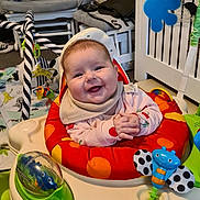 Megan joined the competition — help win amazing prizes! baby, smiling, infant, baby_seat, toy, colorful, indoor, child, happy, clothing, face, play, activity_center, seat, hand, expression, cute, cheerful, home, young