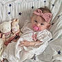 baby, infant, pacifier, headband, pink, white_dress, lace, tights, plush_toy, bunny, bedspread, stars, cute, child, portrait, indoors, resting, soft_toys, blanket, adorable