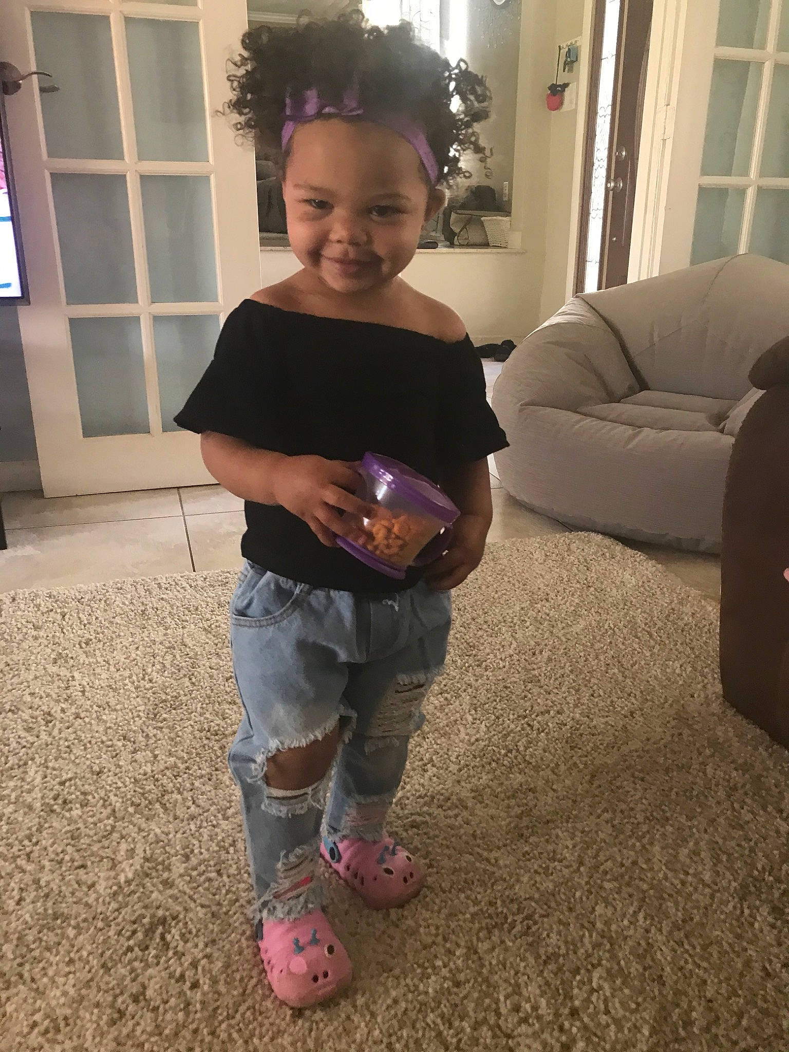 Bryleigh is registered to the contest to win money with this photo: arm, child, floor, flooring, footwear, jeans, joint, joy, knee, leg, person, shoe, shoulder, skin, smile, standing, t_shirt, toddler, trunk