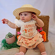 Emory is registered to the contest to win money with this photo: baby, carrot_toy, child, clothing, cup, curious, cute, decor, dollar_bills, easter_theme, green_grass, indoor, plush_toy, portrait, shirt, sitting, skirt, socks, straw_hat, wicker_basket