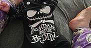 Andrew joined the competition — help win amazing prizes! baby, infant, child, newborn, face, portrait, lying_down, bed, bedroom, skeleton_costume, black_clothing, hat, onesie, pajamas, adult_feet, family, indoor, cozy, funny, photograph