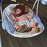 baby, infant, sleeping, monkey_costume, bouncer, baby_seat, diaper, plush_toy, carrot_toy, hanging_toy, nursery, indoor, wood_floor, blanket, portrait, peaceful, cute, costume, seated, face