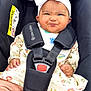 Eliana joined the competition — help win amazing prizes! baby, black_car_seat, car_seat, child, clothing, cute, floral_outfit, funny_expression, hands, headband, indoor, infant, person, pink_pants, portrait, scrunched_face, seatbelt, sitting, straps, white_bow