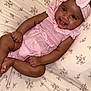 baby, infant, smiling, pink_outfit, headband, lying_down, floral_pattern, bedspread, cute, child, happy, skin, face, hands, feet, indoors, portrait, toddler, young_child, sleepwear