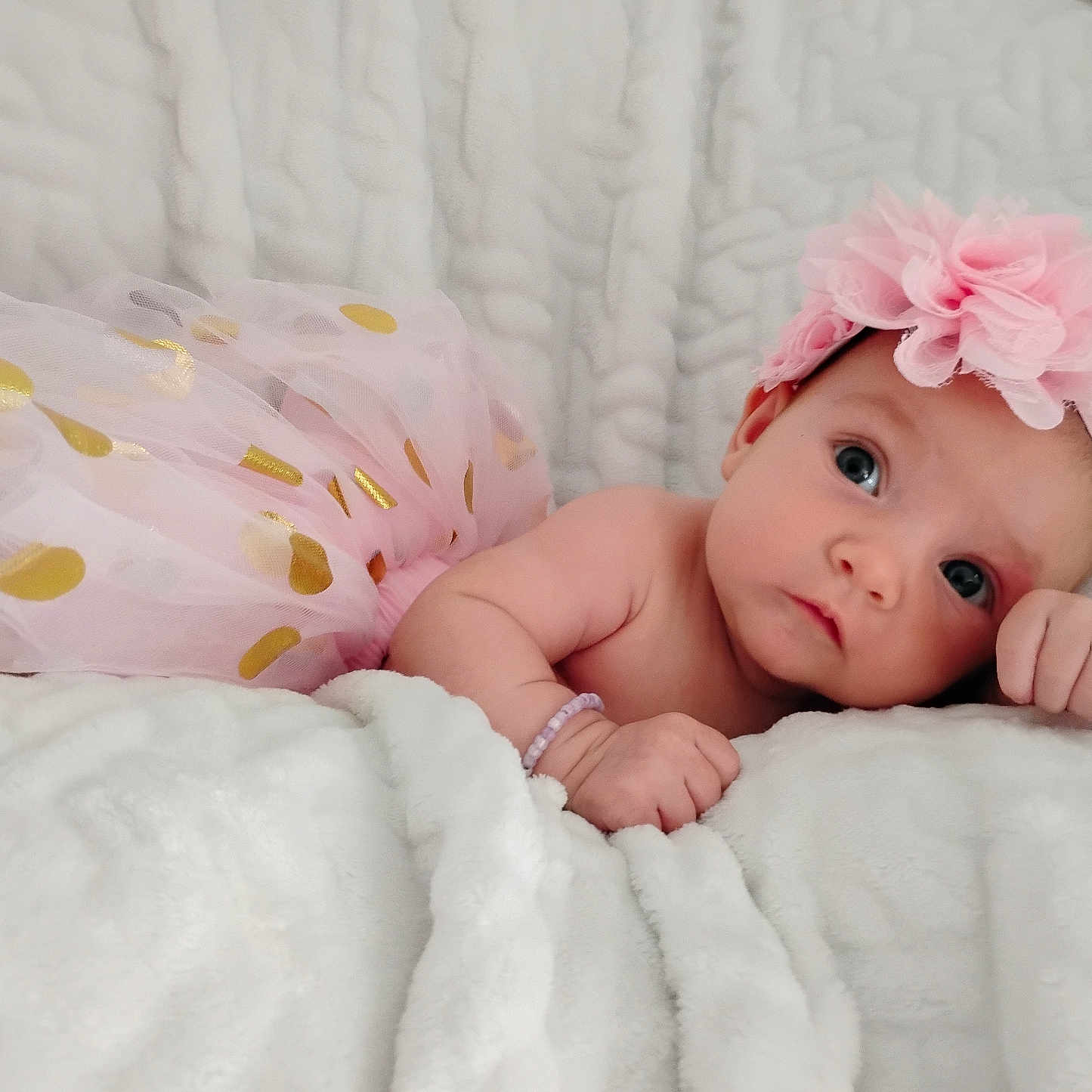 Brynlee is registered to the contest to win money with this photo: adorable, baby, blanket, child, closeup, cute, expression, face, flower, hand, headband, indoors, infant, pink, portrait, resting, skin, sleepwear, soft, tutu