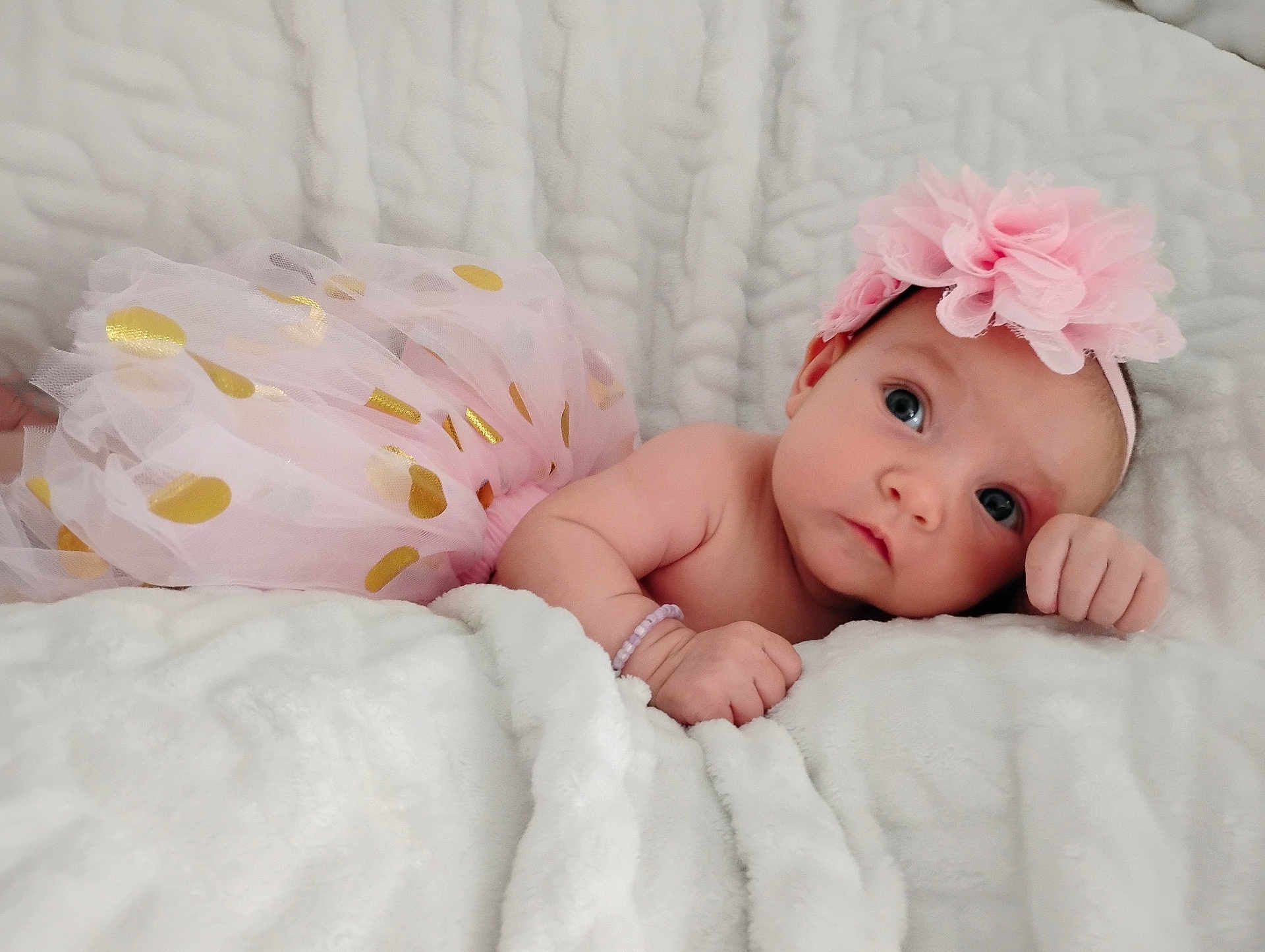 Brynlee is registered to the contest to win money with this photo: baby, infant, tutu, pink, headband, flower, blanket, soft, cute, child, portrait, indoors, resting, sleepwear, closeup, skin, hand, face, expression, adorable