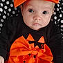 Brynlee is registered to the contest to win money with this photo: baby, infant, child, face, eyes, orange_bow, orange_dress, black_clothing, pumpkin_print, halloween, polka_dot_blanket, cute, portrait, indoor, young_child, expression, headband, hands, sitting, costume