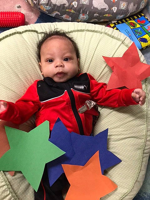 Maison is registered to the contest to win money with this photo: baby, baby_products, baby_toddler_clothing, carmine, child, christmas_eve, comfort, event, happy, holiday, linens, outerwear, pattern, person, product, red, sitting, sleeve, textile, toddler