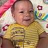 baby, smiling, infant, striped_shirt, yellow, honey_pot, bee, blanket, floral_pattern, cute, happy, lying_down, child, portrait, indoors, skin, face, arms, clothing, young
