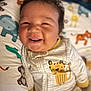 Kyler is registered to the contest to win money with this photo: baby, smiling, infant, onesie, animal_print, cushion, elephant, giraffe, tiger, monkey, cute, happy, face, child, portrait, indoors, soft_focus, sleepwear, playful, young_child