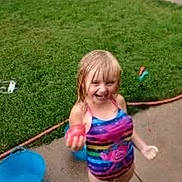 Aubryana is registered to the contest to win money with this photo: child, girl, swimsuit, colorful_clothing, water_play, outdoor, grass, bucket, sidewalk, wet_surface, summer, fun, smiling, blond_hair, playful, water_toy, happy, young, person, daylight