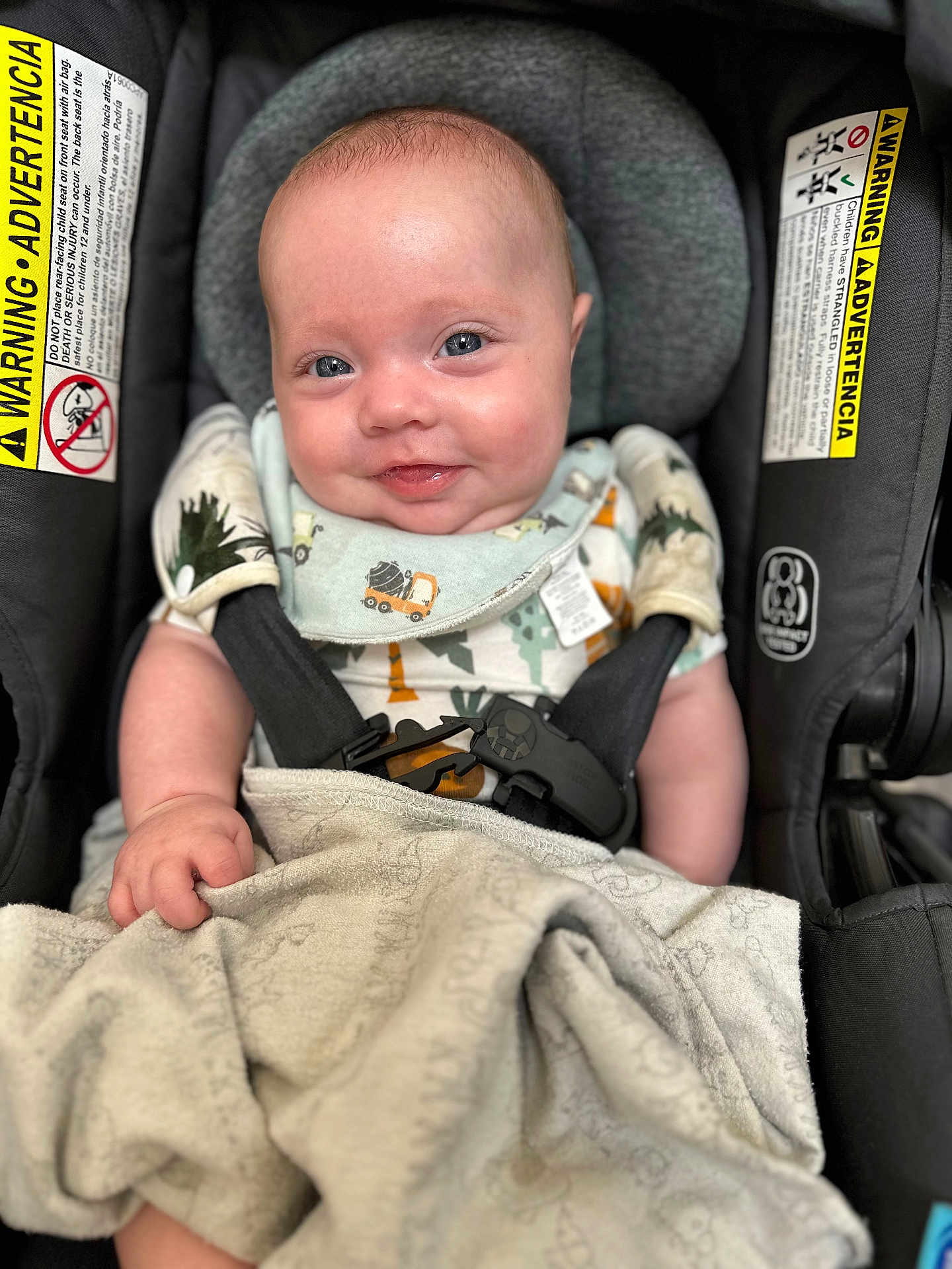 Jesiah is registered to the contest to win money with this photo: baby, infant, car_seat, blanket, smile, blue_eyes, clothing, buckle, safety, child, cute, indoor, portrait, happy, seat_belt, fabric, soft, head_support, person, closeup