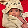 baby, towel, hood, infant, wrapped, cute, red_background, face, hand, skin, eyes, blanket, clothing, expression, portrait, newborn, soft, child, lying_down, indoor