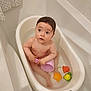 baby, bathtub, bathroom, water, toy, child, cup, bath, toddler, plastic, orange, yellow, green, pink, cute, indoor, skin, wet_hair, looking_up, small_bathtub