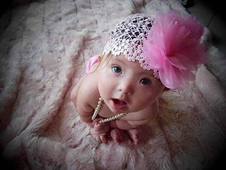 Penny is registered to the contest to win money with this photo: baby, baby_toddler_clothing, cap, child, costume_hat, embellishment, fashion_accessory, flash_photography, fur, hair_accessory, happy, hat, headgear, headpiece, headwear, knit_cap, lip, magenta, person, petal