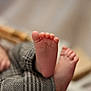 Badis participe au concours pour gagner de l'argent avec cette photo : baby, feet, toes, pants, patterned_clothing, close_up, soft_focus, blurred_background, infant, skin, child, small_toes, cute, footwear_absent, resting, warm, texture, comfort, indoor, casual
