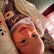 Macie joined the competition — help win amazing prizes! baby, smile, blanket, cushion, face, person, indoor, soft_light, cozy, pattern, head, child, toddler, clothing, fabric, closeup, comfort, rest, happy, portrait