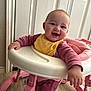 Macie is registered to the contest to win money with this photo: baby, smiling, indoor, baby_walker, yellow_bib, purple_clothing, wooden_floor, white_door, happy, child, person, face, infant, walker, floor, pink, cute, home, young_child, standing