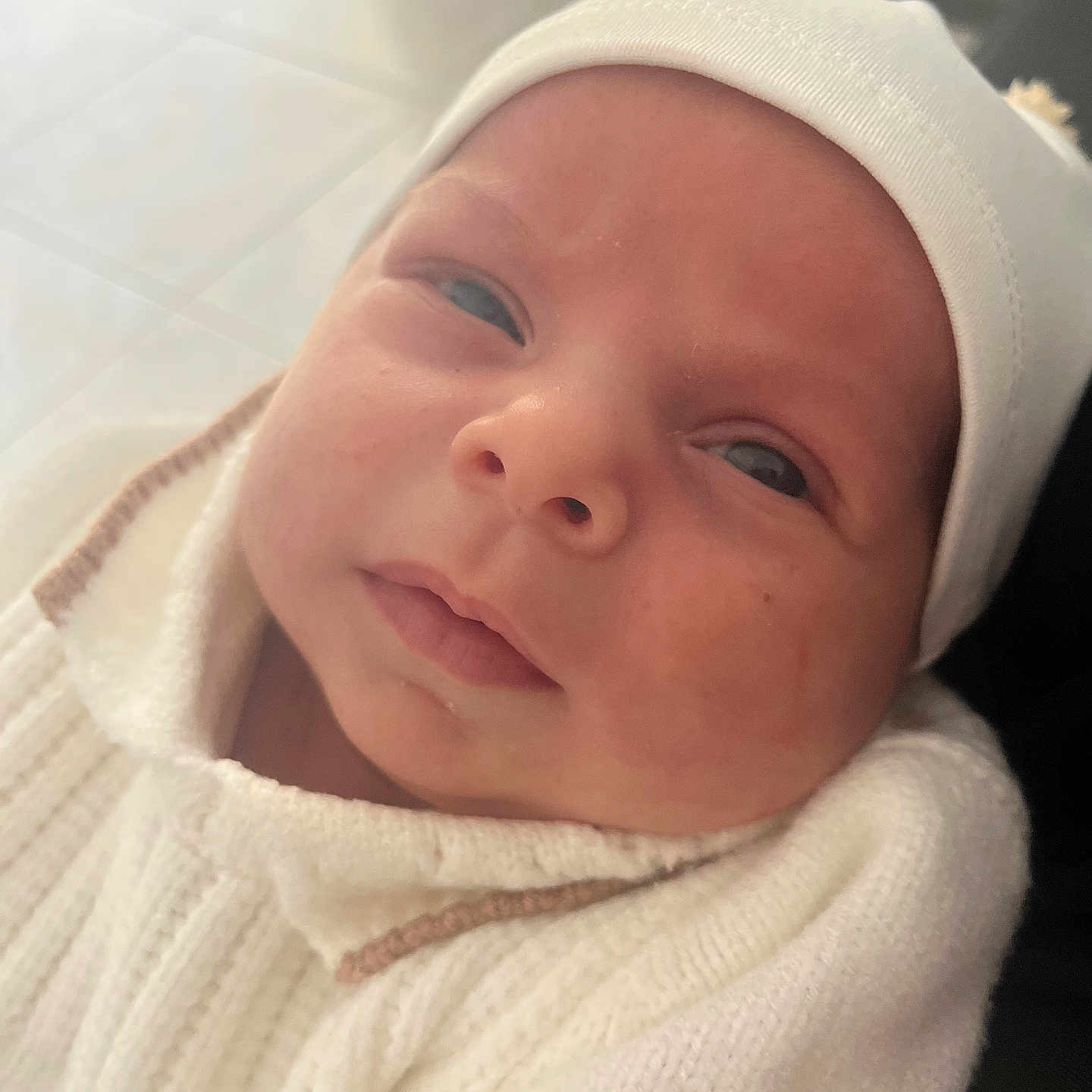 Cataleya a rejoint le concours — aidez-le/la à gagner de superbes lots ! baby, child, close_up, curious, expression, face, hat, headwear, indoors, infant, knitwear, newborn, person, pom_poms, portrait, skin, soft_lighting, sweater, warm_clothing, white_clothing