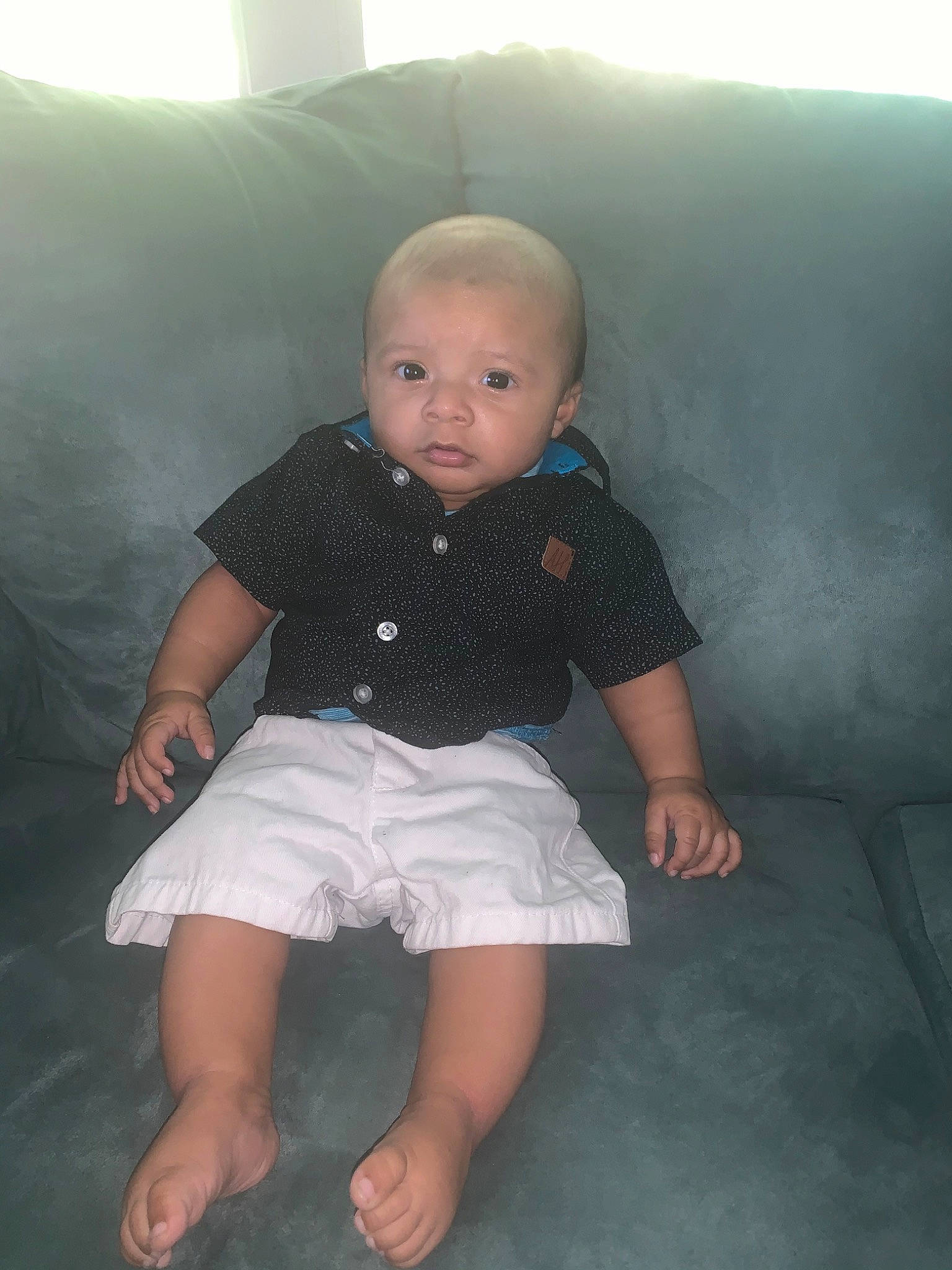 Dylan is registered to the contest to win money with this photo: arm, baby, cheek, child, face, fun, head, leg, person, sitting, skin, smile, standing, toddler, vacation