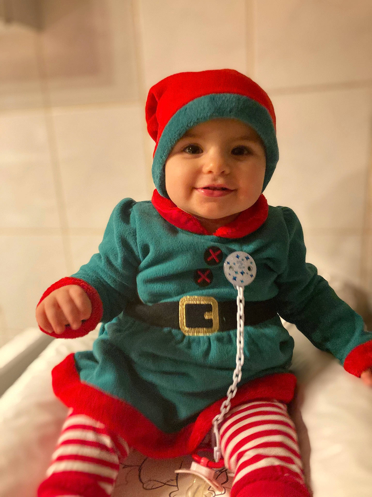 Lyana participe au concours pour gagner de l'argent avec cette photo : baby, baby_toddler_clothing, cap, christmas_ornament, clothing, costume_hat, face, fun, happy, head, headgear, headwear, human_body, joy, leg, outerwear, person, red, skin, sleeve