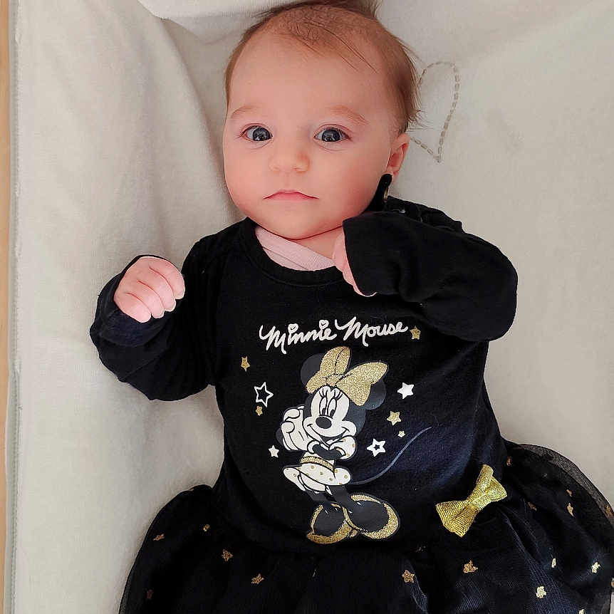 Elyana a rejoint le concours — aidez-le/la à gagner de superbes lots ! baby, black_dress, blanket, child, clothing, cute, expression, face, hands_up, head, indoor, infant, looking_at_camera, lying_down, minnie_mouse, portrait, socks, soft_lighting, sparkles, toddler