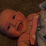 baby, smiling, infant, happy, face, pink_clothing, blanket, carpet, cute, child, skin, tongue, button, eyes, head, cheeks, person, indoors, baby_girl, soft_toy