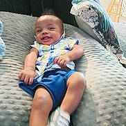 My'Drevious Bell joined the competition — help win amazing prizes! baby, smiling, indoor, pillow, blue_shorts, colorful_shirt, happy, couch, child, person, footwear, white_shoes, plush, relaxing, tongue_out, seated, texture, cozy, furniture, home