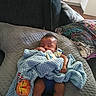 My'Drevious Bell joined the competition — help win amazing prizes! baby, bottle, blanket, blue_blanket, couch, cushion, indoor, infant, kitchen, lion_patch, living_room, person, pillow, resting, sleeping, soft_texture, socks, toddler, toy, young_child