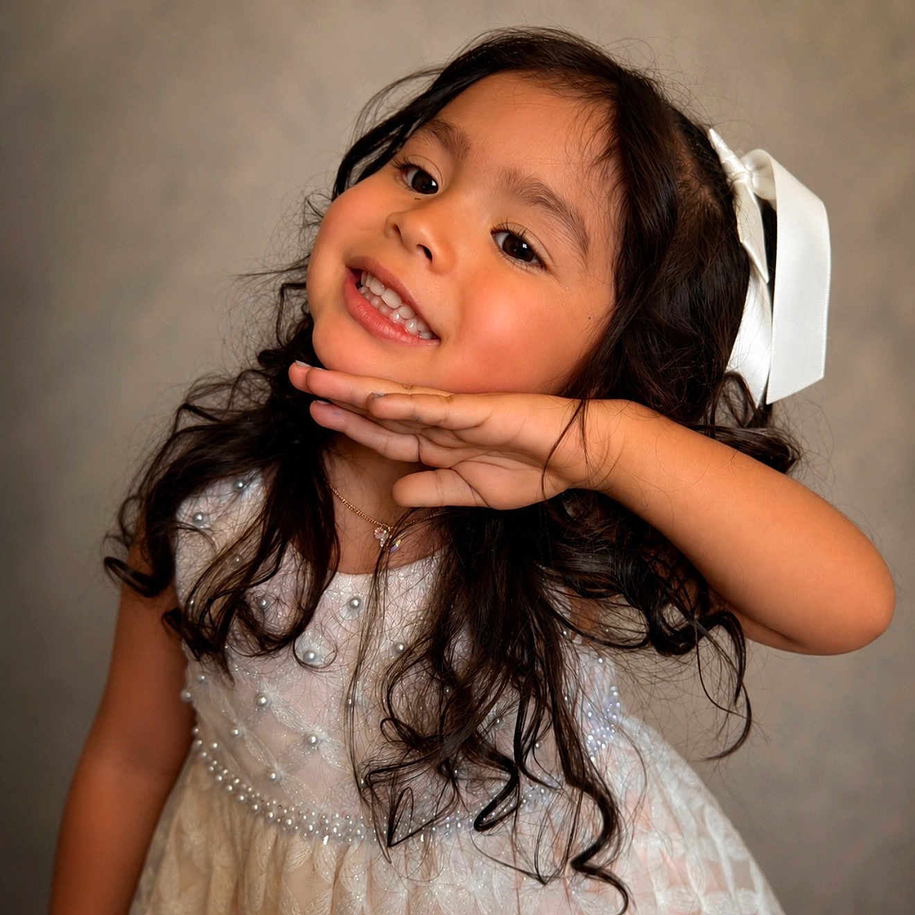 Leiza is registered to the contest to win money with this photo: child, girl, smile, pose, dress, white_dress, pearls, bow, hair, long_hair, curly_hair, portrait, happy, cute, fashion, accessory, necklace, indoor, studio, person