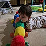 Tatum is registered to the contest to win money with this photo: baby, infant, toy, colorful, carpet, pacifier, caterpillar_toy, indoor, play_area, child, cute, lying_down, soft_lighting, clothing, patterned_onesie, floor, baby_toys, child_playing, home, young_child