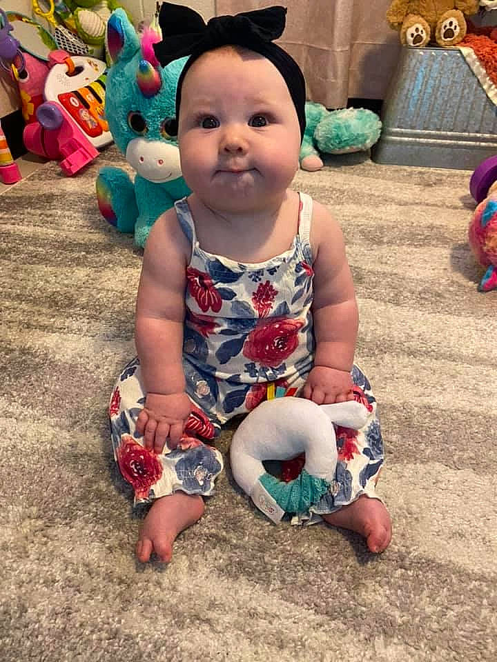 Brexley is registered to the contest to win money with this photo: baby, baby_toddler_clothing, child, dress, event, foot, fun, grass, happy, head, holiday, human_leg, leisure, mammal, person, pink, sitting, skin, summer, toddler