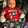 Jaxson is registered to the contest to win money with this photo: baby, child, mickey_mouse, red_shirt, grey_pants, gloves, socks, blanket, pacifier, toy, patterned_blanket, lying_down, cute, wide_eyes, clothing, indoor, infant, person, portrait, cozy