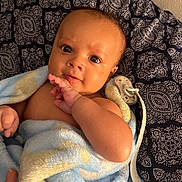 Jaxson is registered to the contest to win money with this photo: baby, infant, blanket, pacifier, hand, face, eyes, cushion, pattern, blue, yellow, skin, person, newborn, portrait, soft, comfort, indoor, closeup, cute