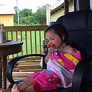 Lindsay joined the competition — help win amazing prizes! child, towel, chair, porch, outdoor, vegetable, tomato, eating, barefoot, wooden, furniture, relaxed, summer, greenery, house, satellite_dish, casual, daylight, person, seated