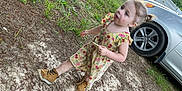 Morgan is registered to the contest to win money with this photo: child, girl, outdoor, dress, boots, car, dirt, grass, tree, tire, curious, walking, nature, face, pigtails, young, casual, daylight, sidewalk, person