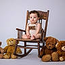 Enzo Calero Cepeda is registered to the contest to win money with this photo: baby, child, toddler, sitting, rocking_chair, wooden_chair, teddy_bears, stuffed_animals, portrait, studio, indoors, white_background, curly_hair, onesie, bare_feet, serious_expression, infant, furniture, soft_toys, centered_composition