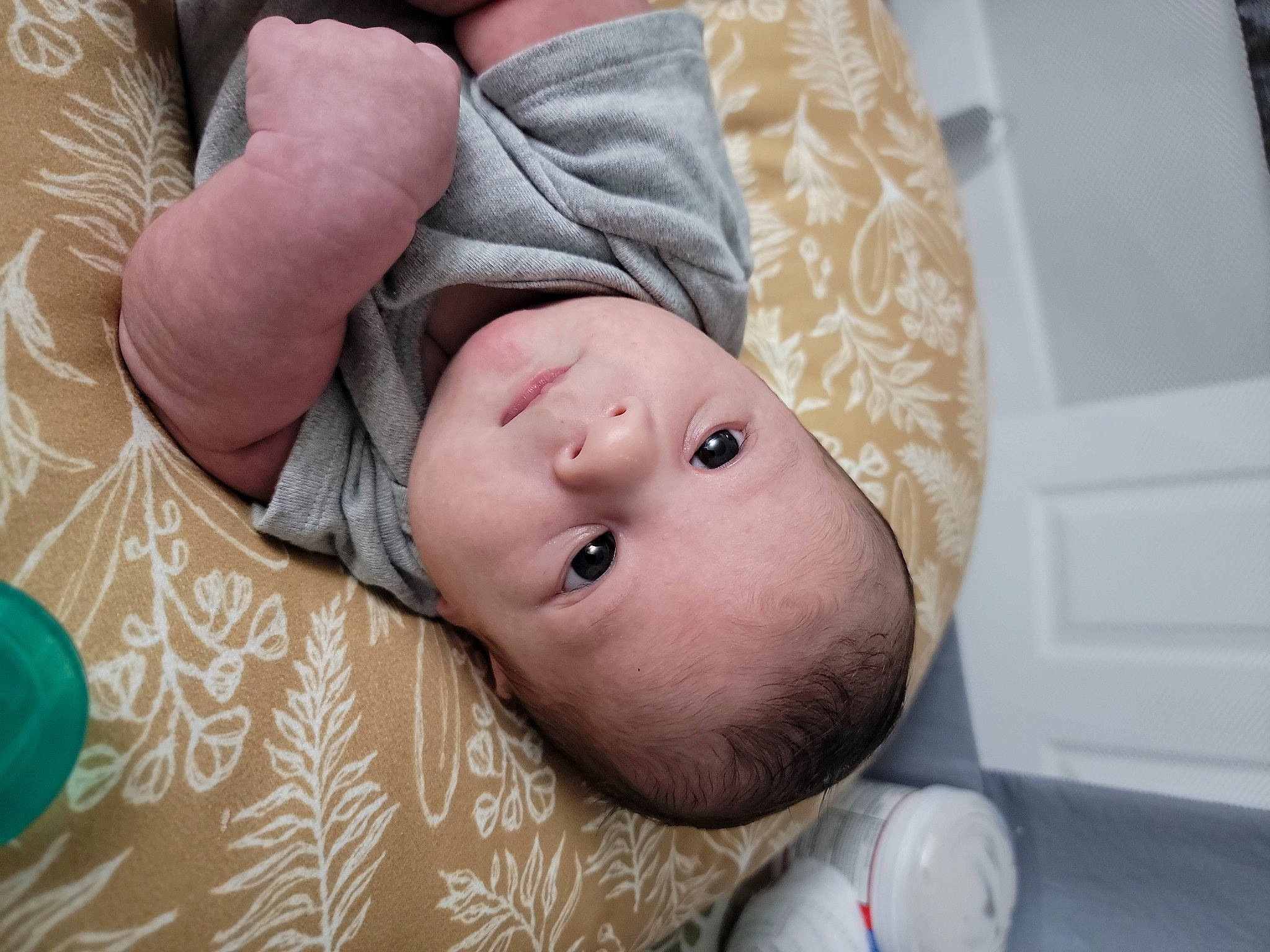 Maddox is registered to the contest to win money with this photo: baby, baby_products, baby_toddler_clothing, cheek, child, comfort, linens, pattern, person, portrait_photography, room, skin, sleeve, toddler, wood