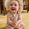 baby, child, smiling, hat, colorful_clothing, carpet, indoor, furniture, crib, happy, cute, portrait, sitting, infant, person, baby_clothes, room, skin, hands, feet