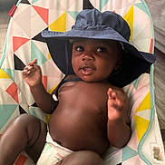 Josias joined the competition — help win amazing prizes! baby, child, hat, diaper, seat, colorful, pattern, indoor, infant, cute, smile, face, hand, relaxing, young, playful, skin, person, comfort, headwear