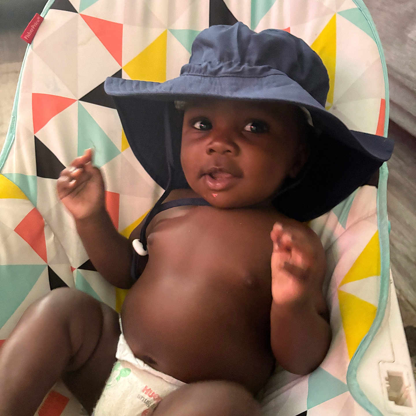 Josias joined the competition — help win amazing prizes! baby, child, colorful, comfort, cute, diaper, face, hand, hat, headwear, indoor, infant, pattern, person, playful, relaxing, seat, skin, smile, young