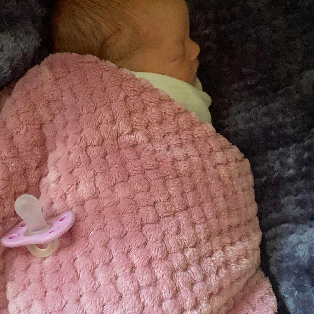 Sabriena is registered to the contest to win money with this photo: newborn, baby, sleeping, blanket, pink, pacifier, cozy, wrapped, resting, infant, soft, plush, texture, child, peaceful, portrait, side_profile, indoor, quiet, comfort