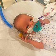 Sabriena joined the competition — help win amazing prizes! newborn, baby, infant, hospital, medical_equipment, pacifier, breathing_tube, blanket, gown, face, hand, lying_down, bed, healthcare, care, premature, tiny, footprint_pattern, white, blue