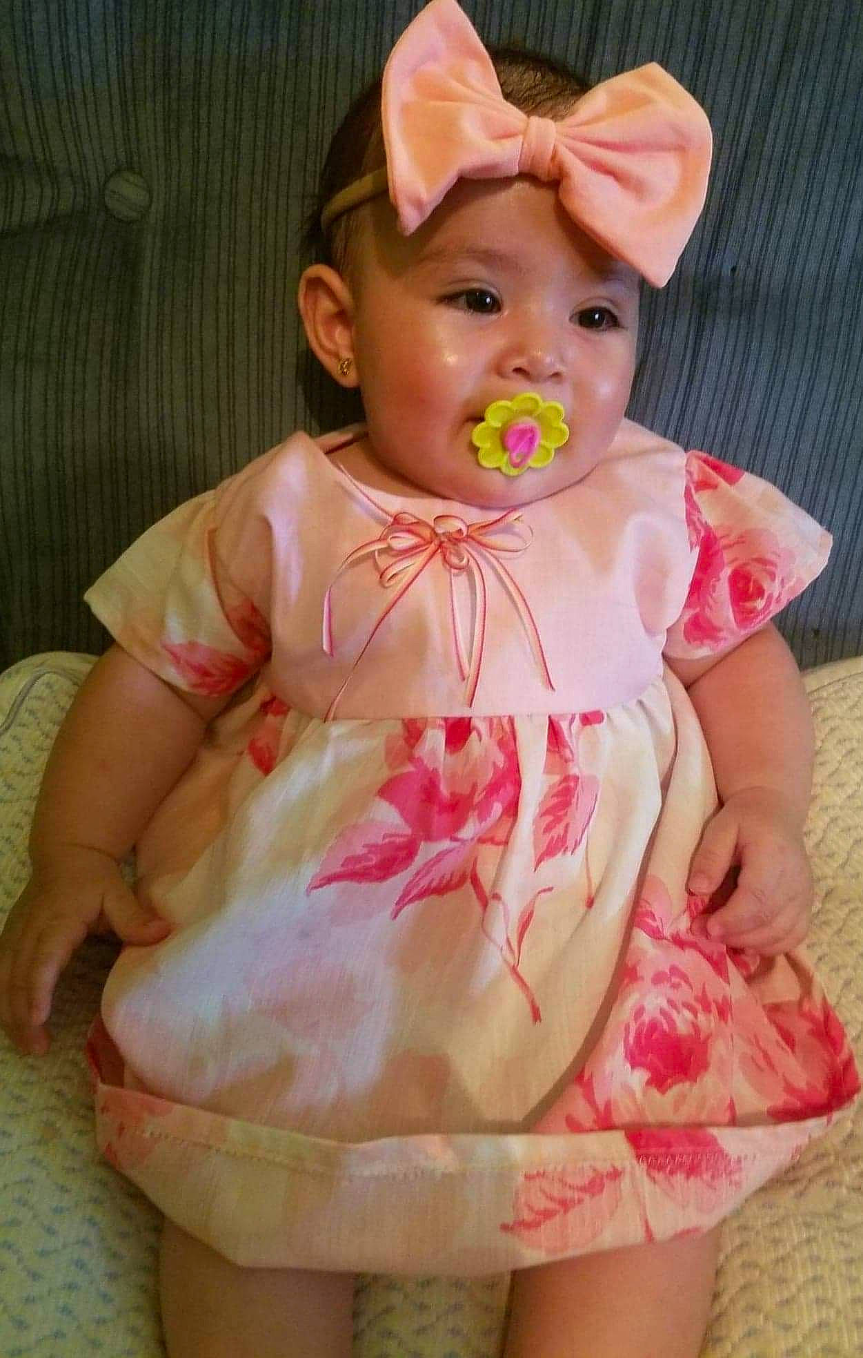 Yudith joined the competition — help win amazing prizes! baby, baby_products, baby_toddler_clothing, bathing, cheek, child, doll, dress, eye, happy, headwear, human_body, iris, pattern, peach, person, pink, sitting, skin, sleeve